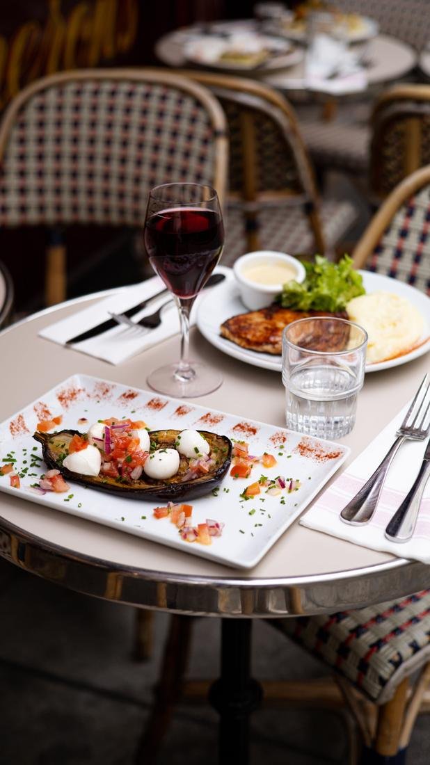 Assiettes et verre de vin sur un guéridon en terrasse