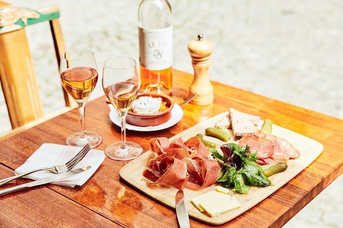 Planche de charcuterie et verres de rosé en terrasse
